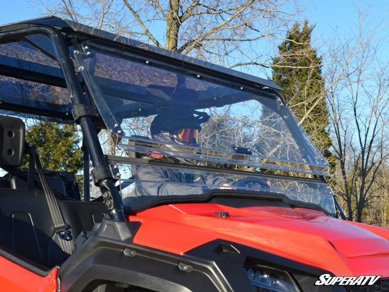 SuperATV flip windshield closed on a red Honda Pioneer 1000, front three-quarter view