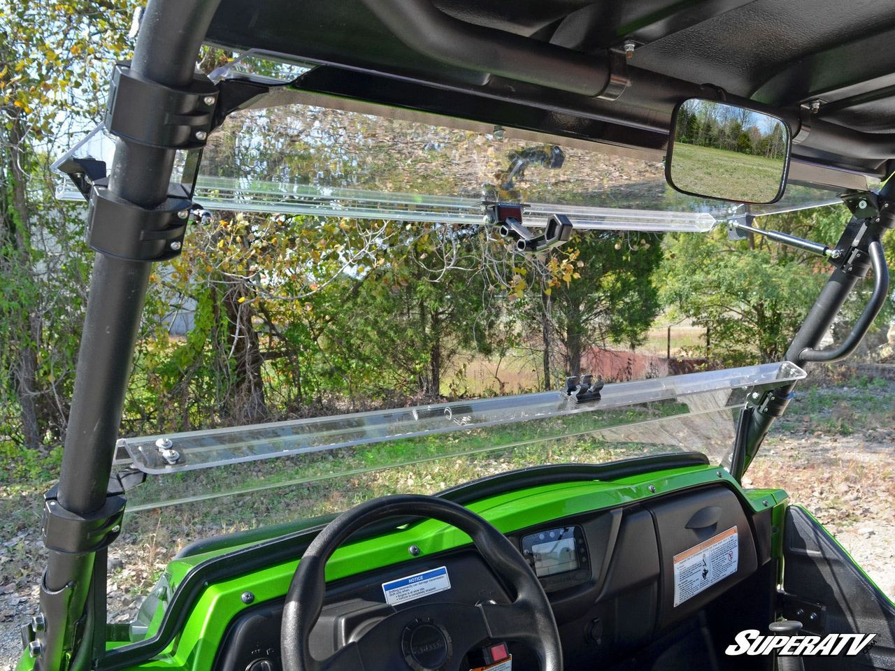 View from inside the Kawasaki Teryx4 cab through the flipped open SuperATV windshield with mirror and wheel