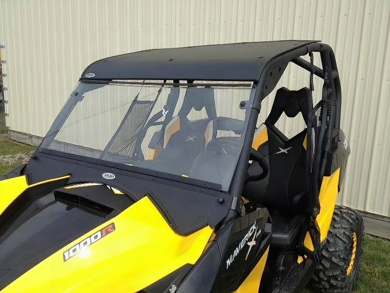 Extreme Metal Products black aluminum top installed on a yellow Can-Am Maverick with windshield, front three-quarter view