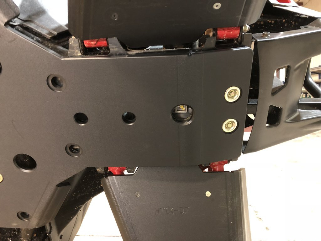Underside view of the Trail Armor skid plate at the front A-arm mount of the Honda Talon with the front bumper