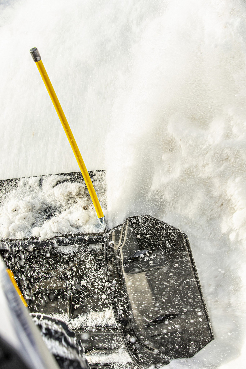 Kolpin yellow snow plow marker rod on the end of a plow blade, close-up as snow is thrown