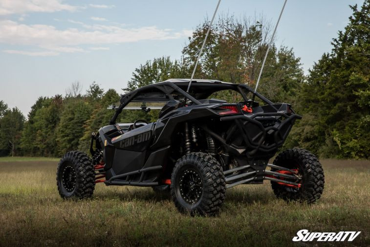 Rear three-quarter view of the Maverick X3 showing the SuperATV nerf bar along the passenger side