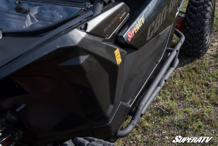 Angled view down the Maverick X3 door showing the SuperATV nerf bar and step tube from above