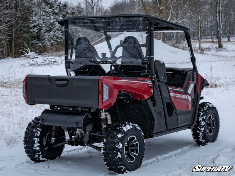 Rear three-quarter view of the red Yamaha Wolverine X2 in snow with the SuperATV rear windshield installed