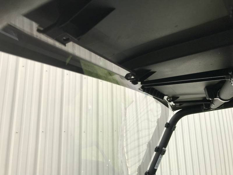 Close-up of the top edge of the Extreme Metal Products windshield sealed under the roof of a Yamaha Wolverine X2