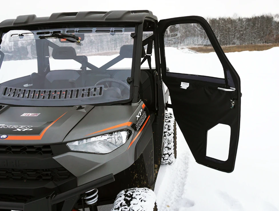 Spike door swung open on a Polaris Ranger XP 1000 parked in snow, front view showing the inside of the door