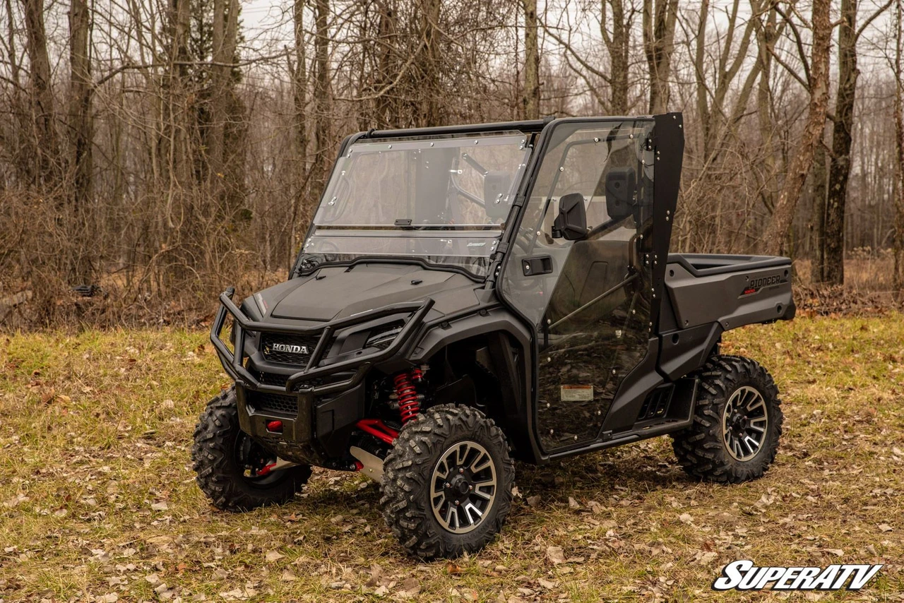 Front three-quarter view of a gray Honda Pioneer 1000 with SuperATV full cab enclosure doors and windshield