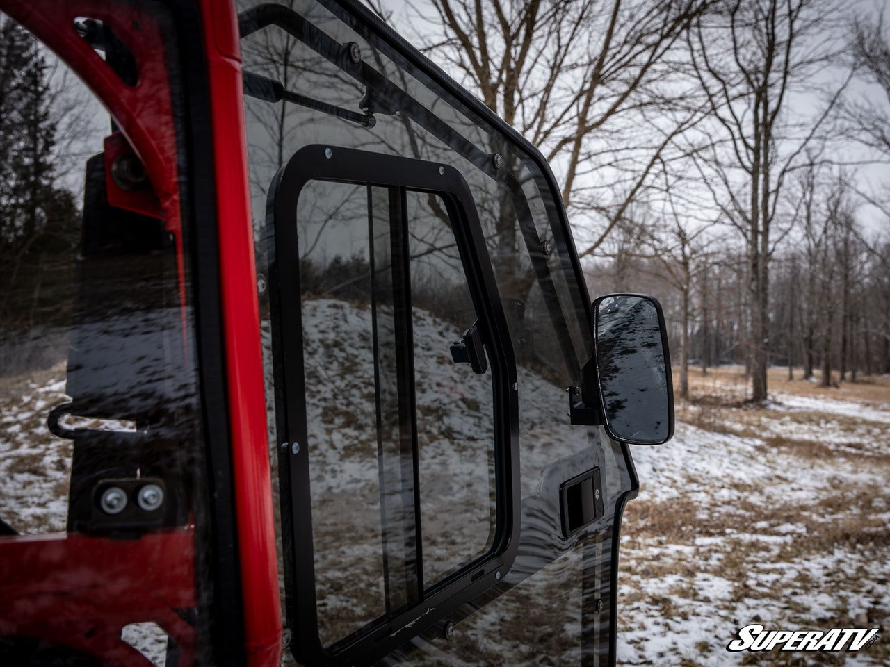 Close-up of the SuperATV full cab door with tinted sliding window and side mirror on a red Polaris General