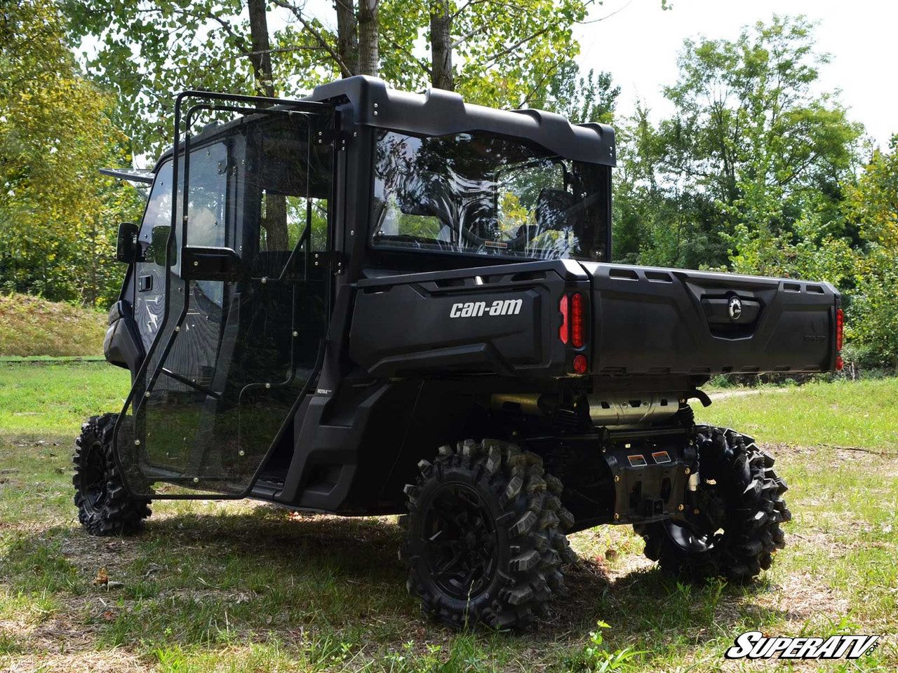 Rear three-quarter view of the Can-Am Defender Max with SuperATV cab doors, cargo bed and tailgate visible