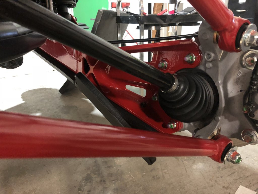 Close-up of the Trail Armor guard on the red Honda Talon 1000 X trailing arm beside the CV axle boot