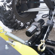 Eagle hydraulic motion pac pump and spring on a UTV plow frame beside the track, small close-up in snow