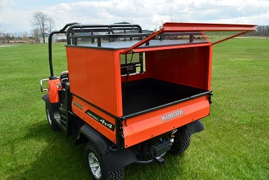 Wiedmann Bros bed cap with the glass rear door lifted open showing the Kubota RTV 900/1100 bed interior