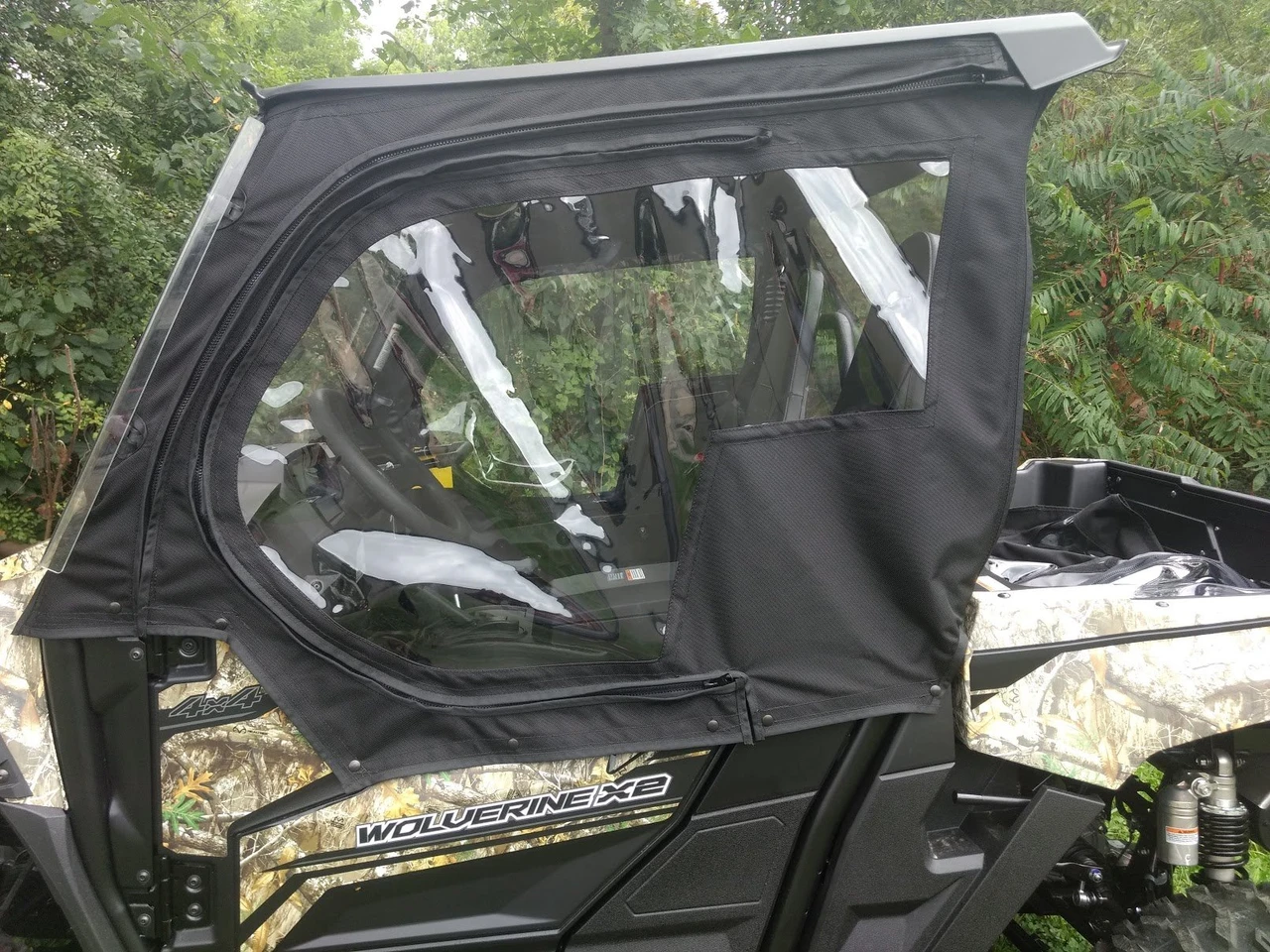Close-up of the Side X Side upper door with clear window and zipper on a camo Yamaha Wolverine X2