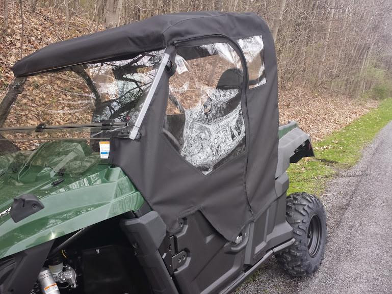 Front three-quarter view of the Side X Side full cab enclosure with windshield and roof on a green Yamaha Wolverine