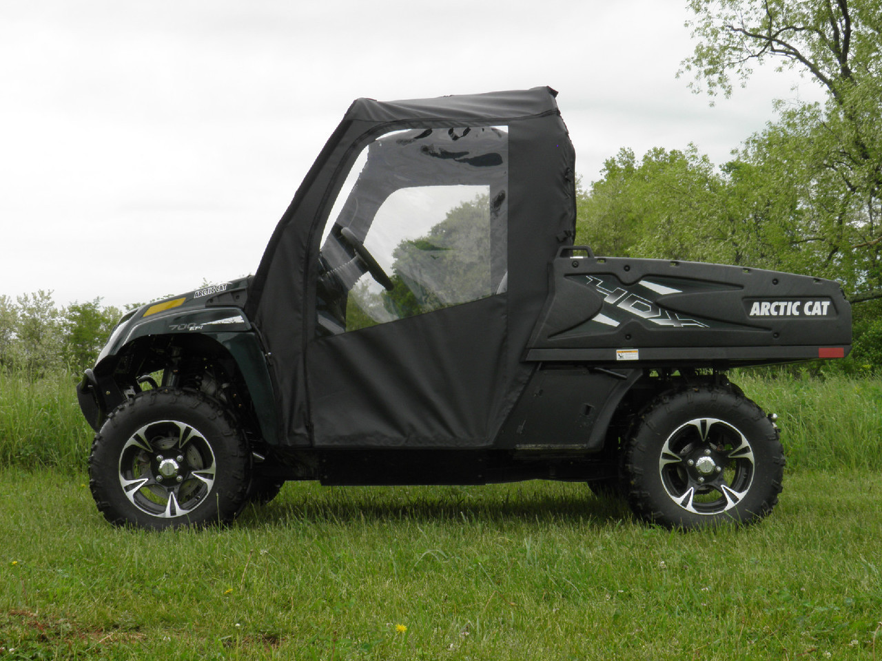 Side view of an Arctic Cat Prowler 550 with the 3 Star soft doors and top installed, parked on grass