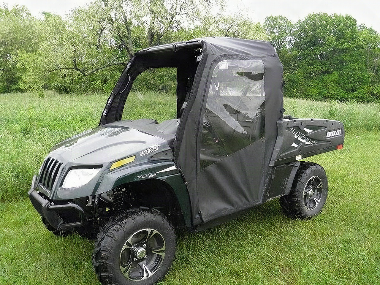 3 Star black soft doors with clear windows installed on a green Arctic Cat Prowler 700 in a field, front three-quarter view