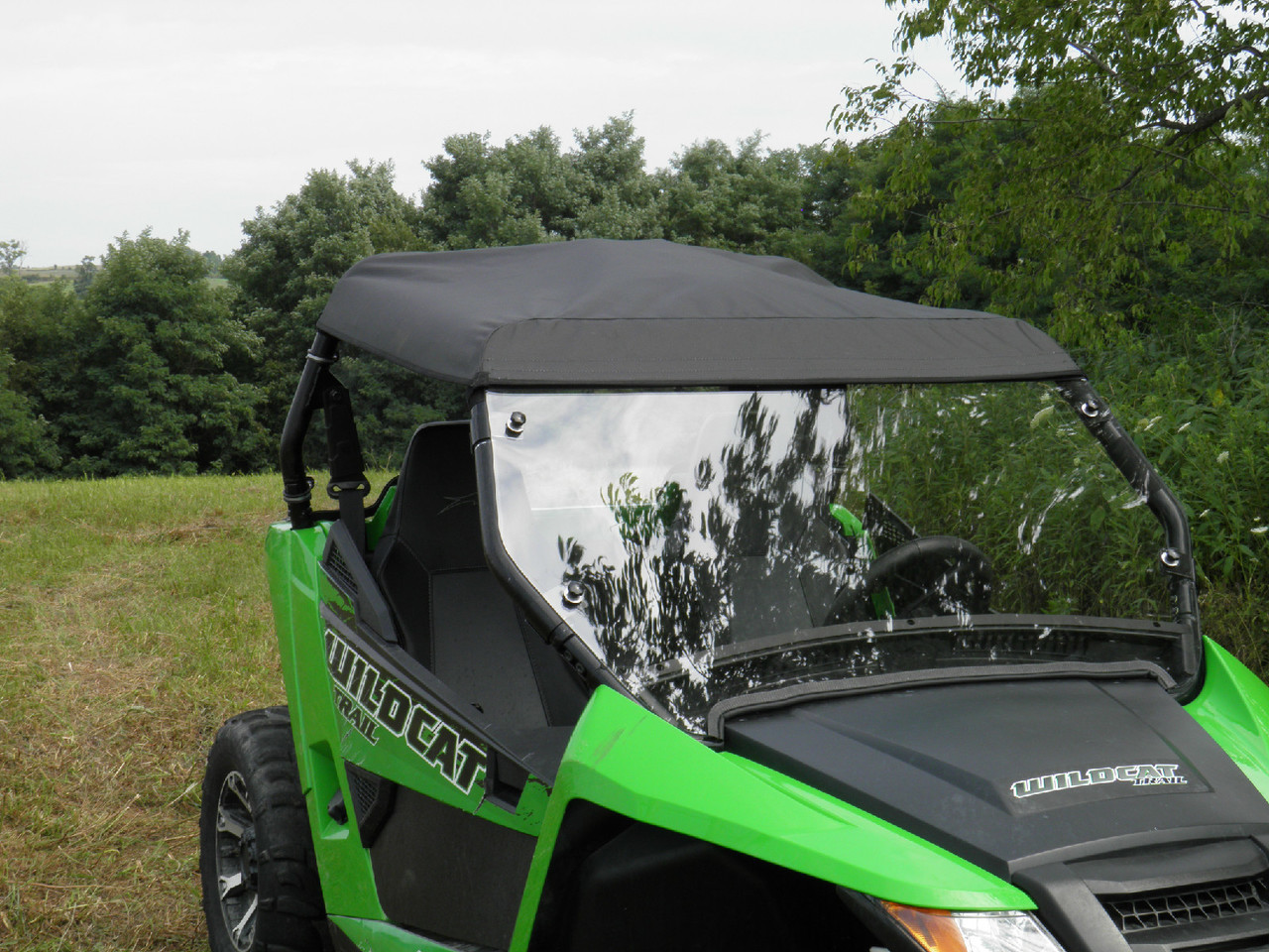 3 Star black soft top installed on the cage of a green Arctic Cat Wildcat X, front three-quarter view