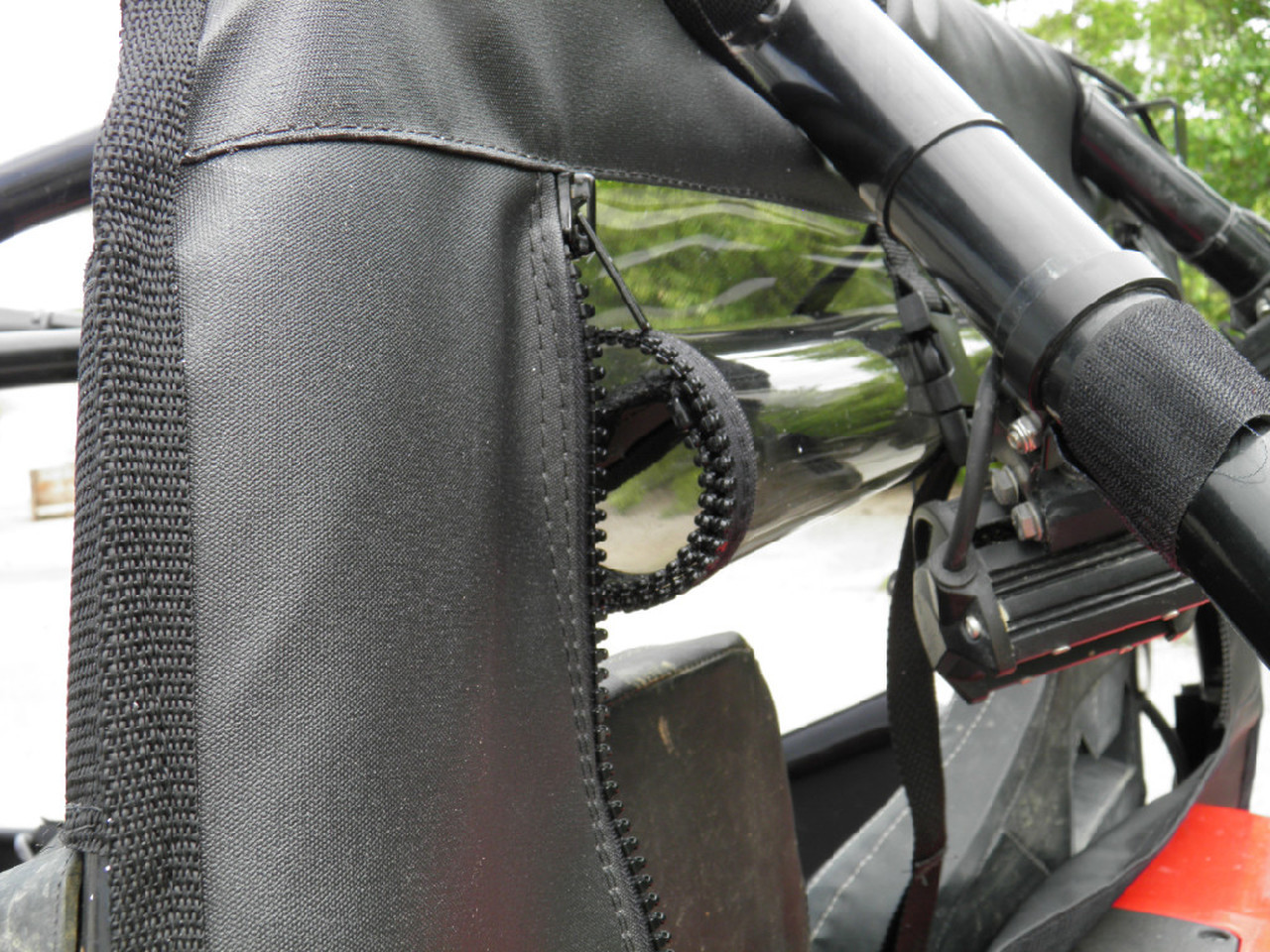 Close-up of the zipper and strap securing the 3 Star soft back panel to the Arctic Cat Wildcat 4 cage
