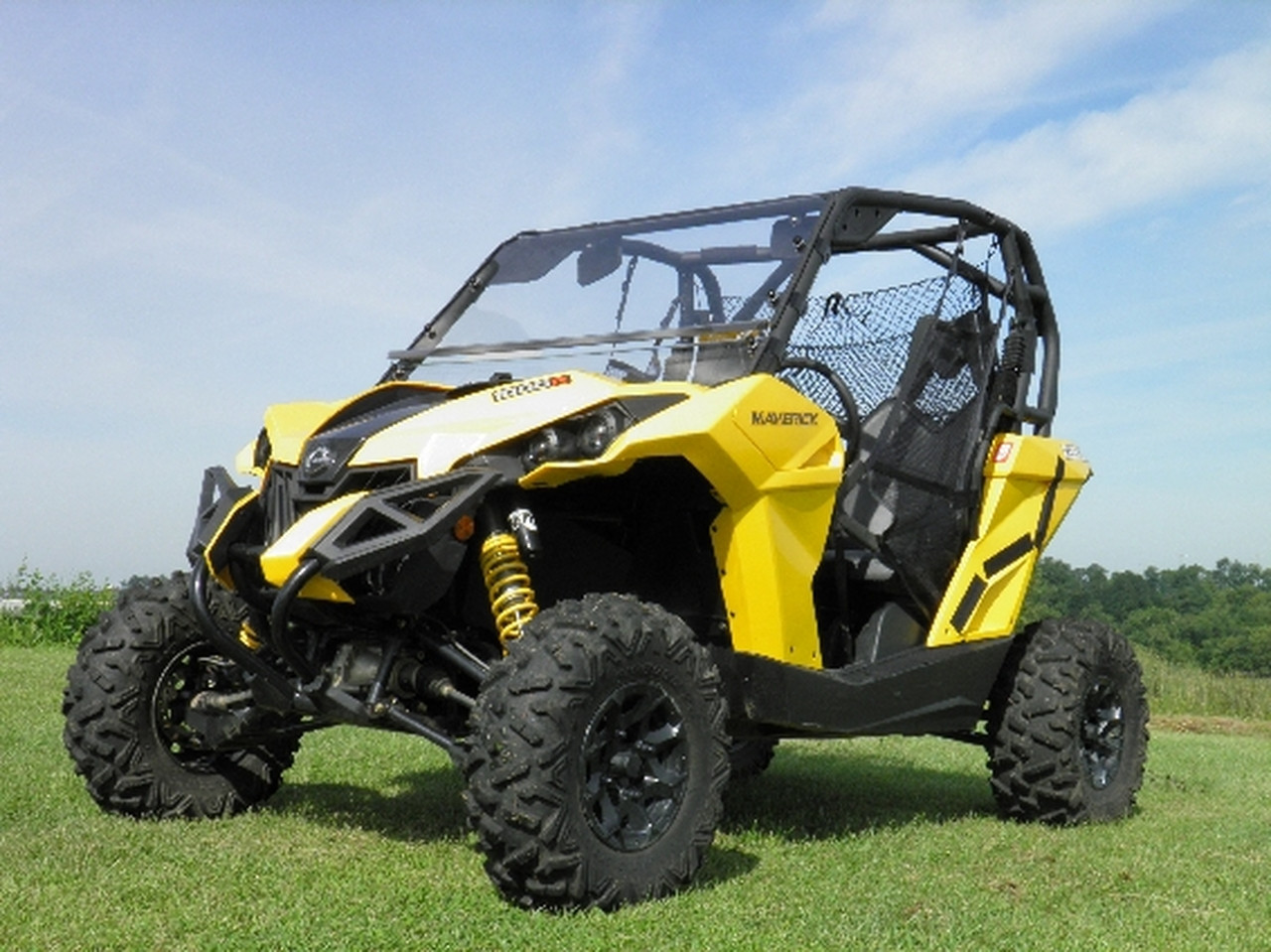 Front three-quarter view of a yellow Can-Am Maverick with the 3 Star two-piece scratch-resistant windshield