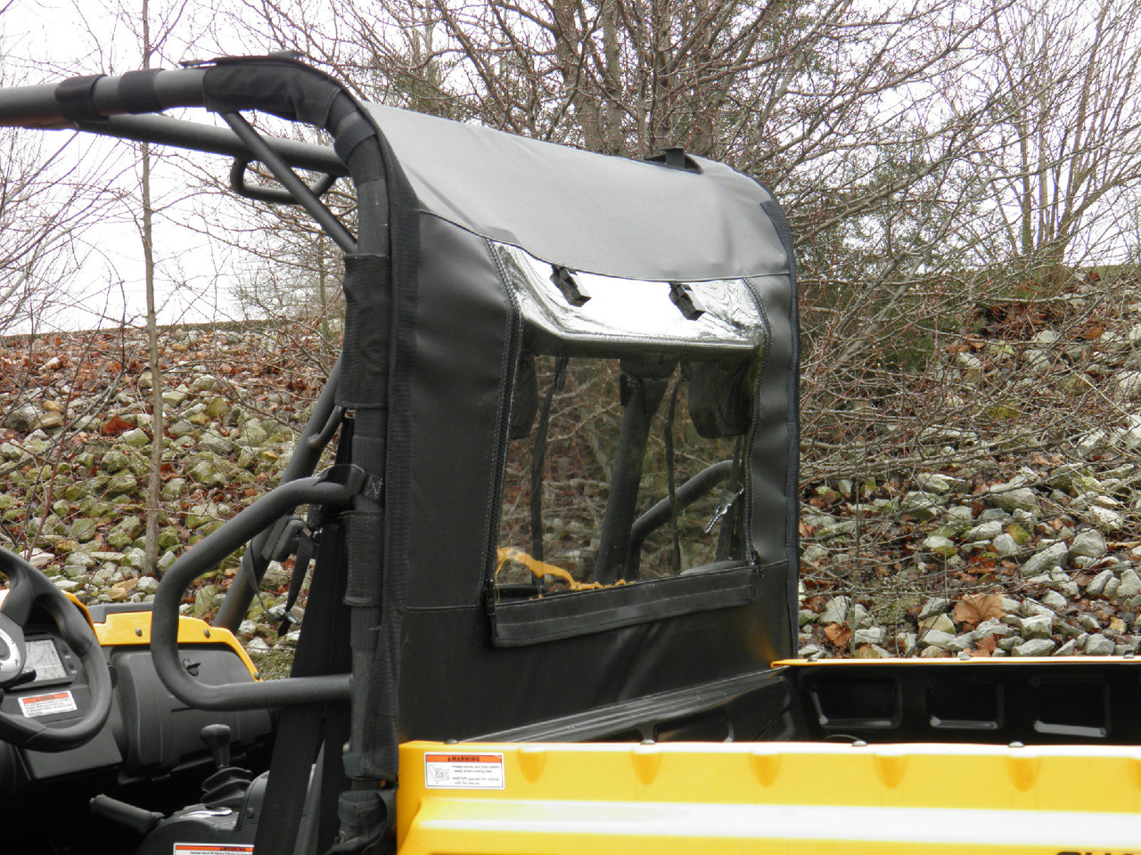 Rear view of the 3 Star soft back panel with clear window and zipper on a yellow side-by-side, bed in foreground