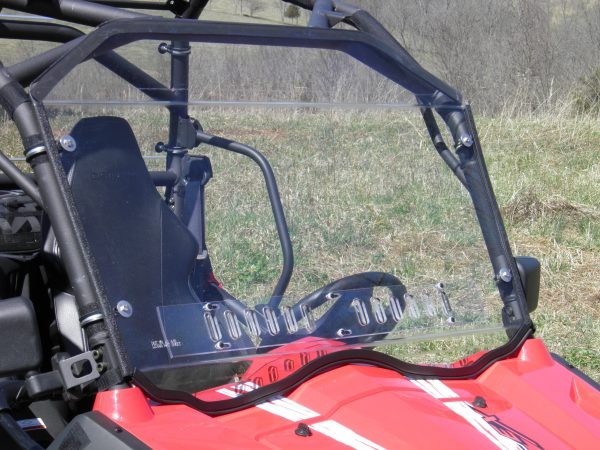 Side angle of the 3 Star scratch-resistant windshield clamped to the cage of a red CF Moto ZForce, vent slots closed