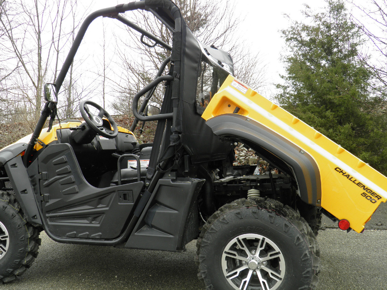 Side view of a yellow Cub Cadet Challenger 500 with the bed raised, showing the 3 Star rear window panel behind the cab