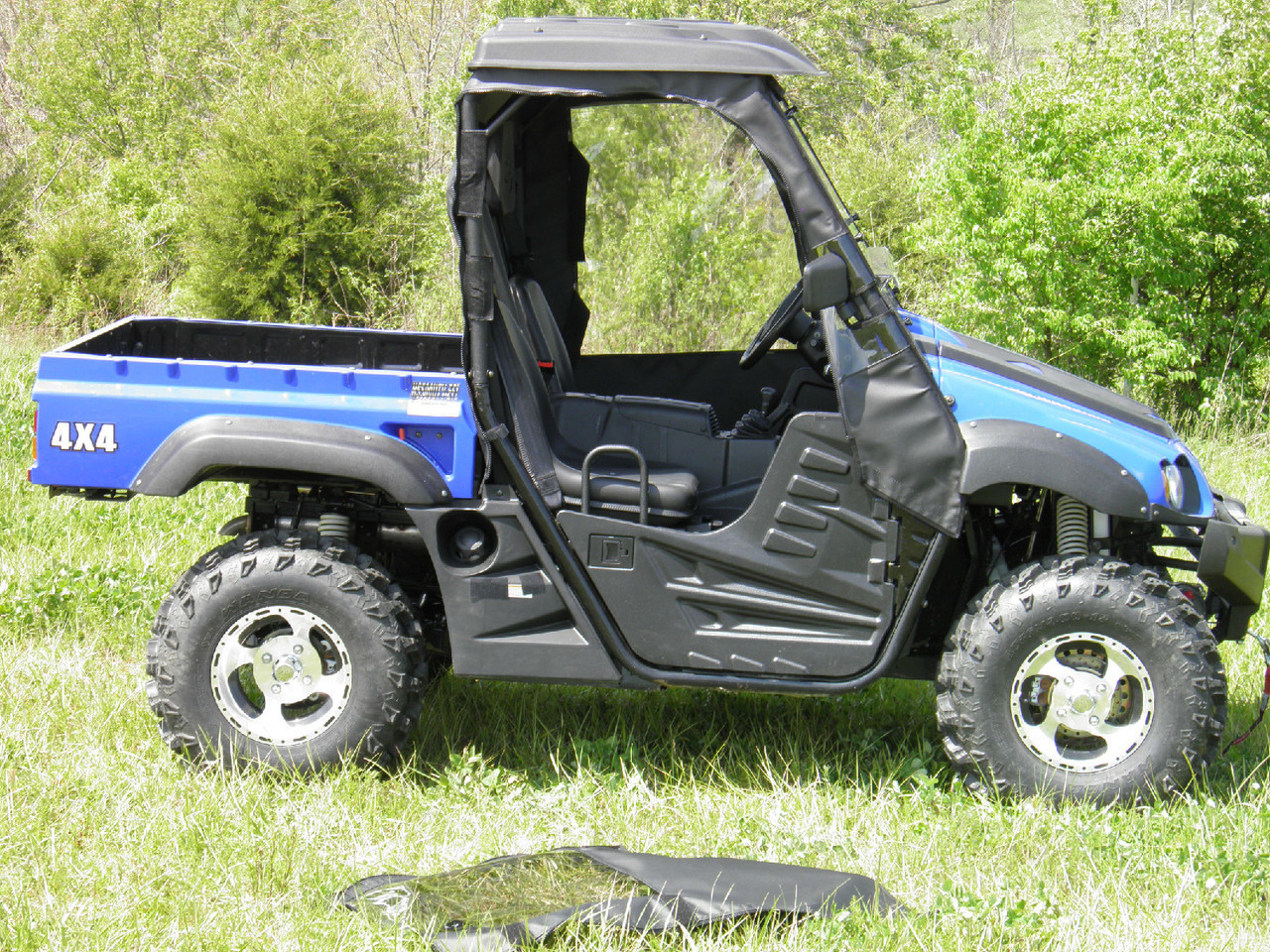 Blue Hisun 500/700 with the 3 Star soft door removed and lying on the ground, side view