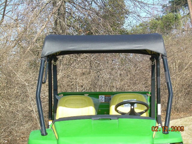 Rear view of the 3 Star soft top stretched over the roll cage above the yellow seats of the John Deere Gator