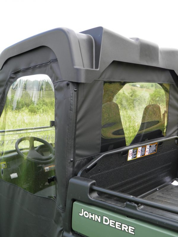 Close-up from the bed of the 3 Star rear window panel with clear window on a green John Deere Gator XUV