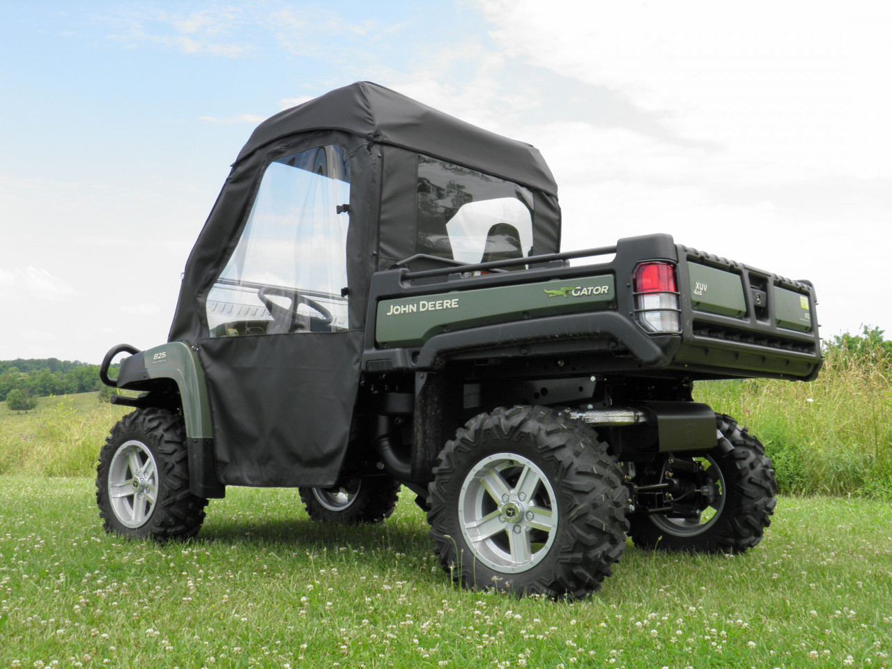 Rear passenger side view of the John Deere Gator XUV with the 3 Star enclosure, rear window and tailgate
