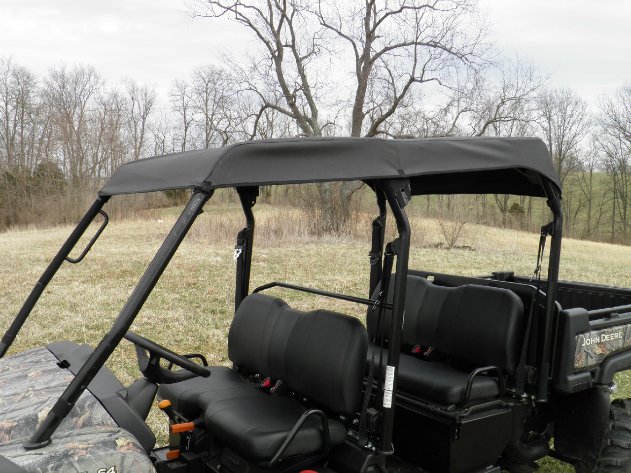 Side view of the 3 Star soft top covering both rows of seats on the camo John Deere Gator XUV-4