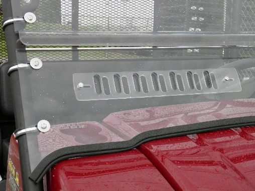 Close-up of the 3 Star windshield vent slots, clamp knobs and rubber edge over a red hood
