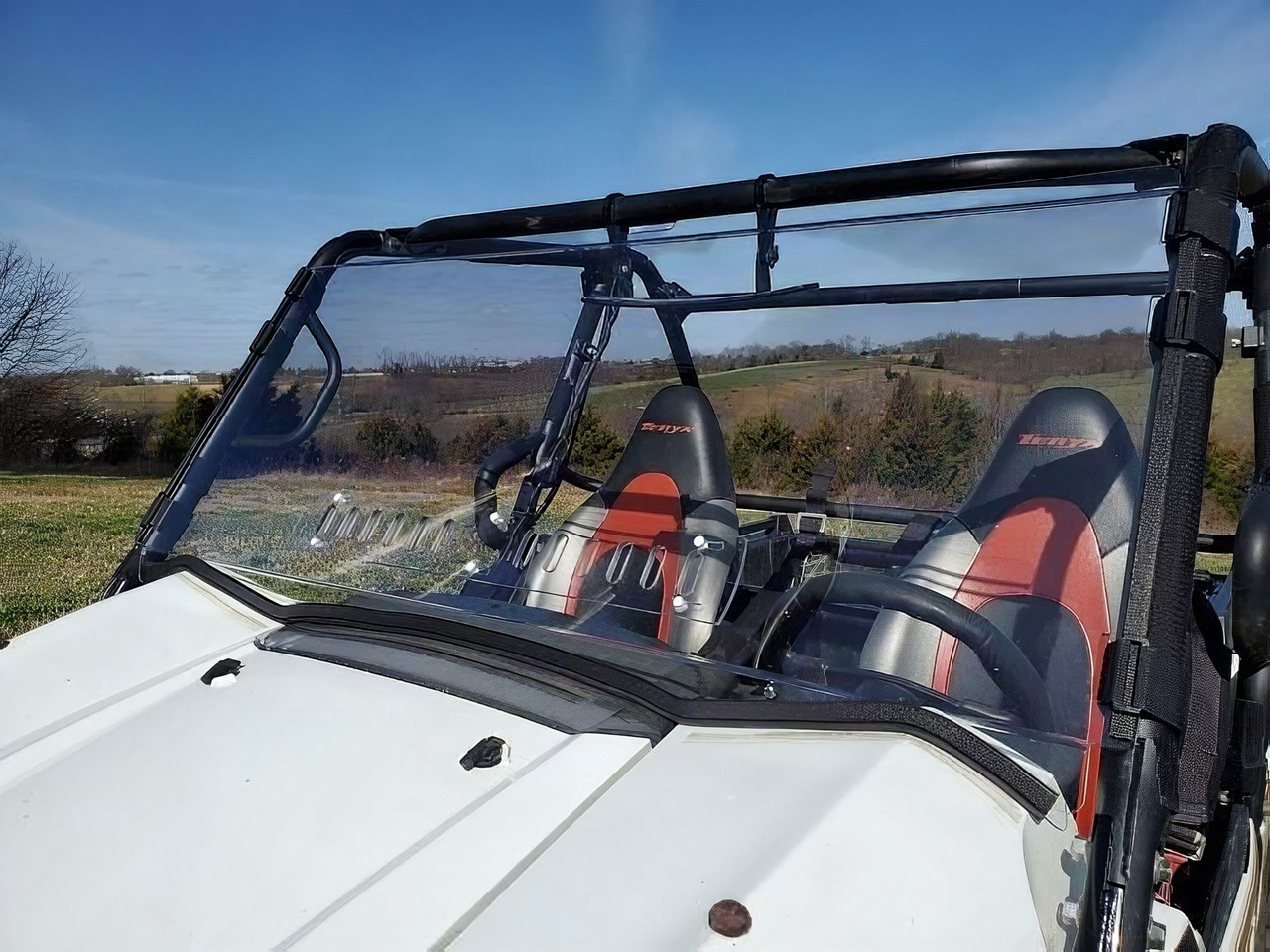 3 Star one-piece scratch-resistant windshield on a white Kawasaki Teryx, front three-quarter close-up in a field