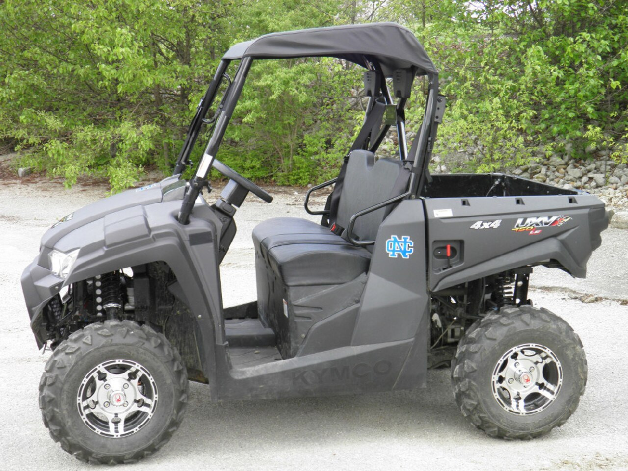 Driver side profile of the gray Kymco 450 with the 3 Star soft top installed, front to back view