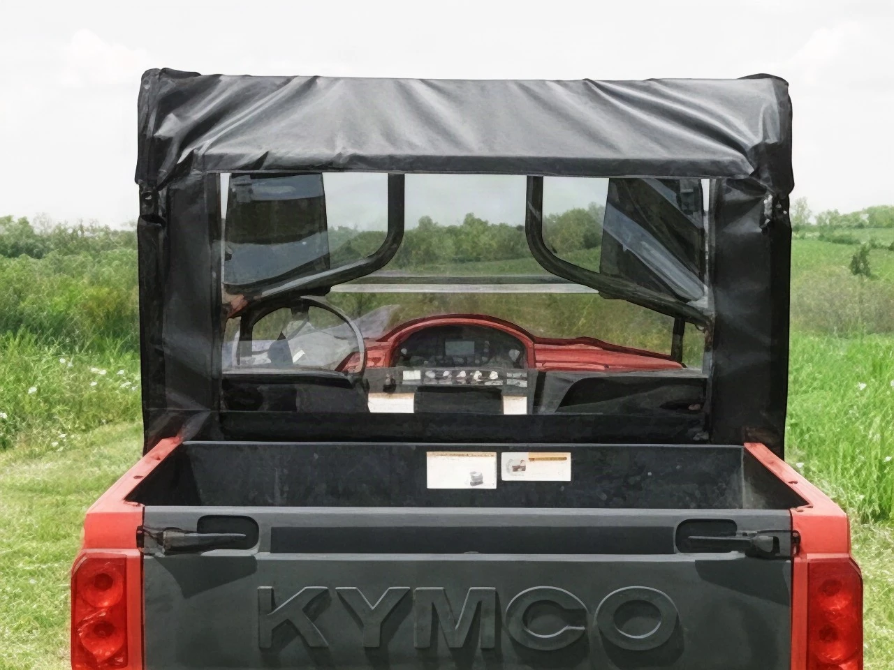 3 Star soft back panel with clear window over the cargo bed of a red Kymco 500, straight rear view