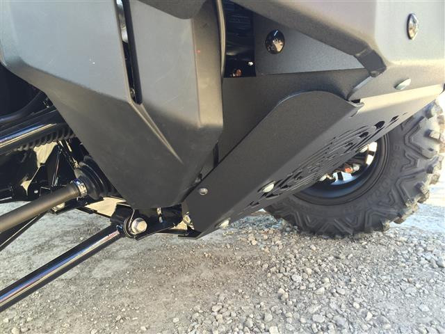 Low side angle of the Extreme Metal Products bumper lower skid wing beside the front tire of the Pioneer 1000 on gravel