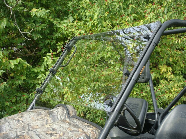 Passenger side angle of the 3 Star two-piece windshield showing the hinge split and cage clamps on the Yamaha Rhino