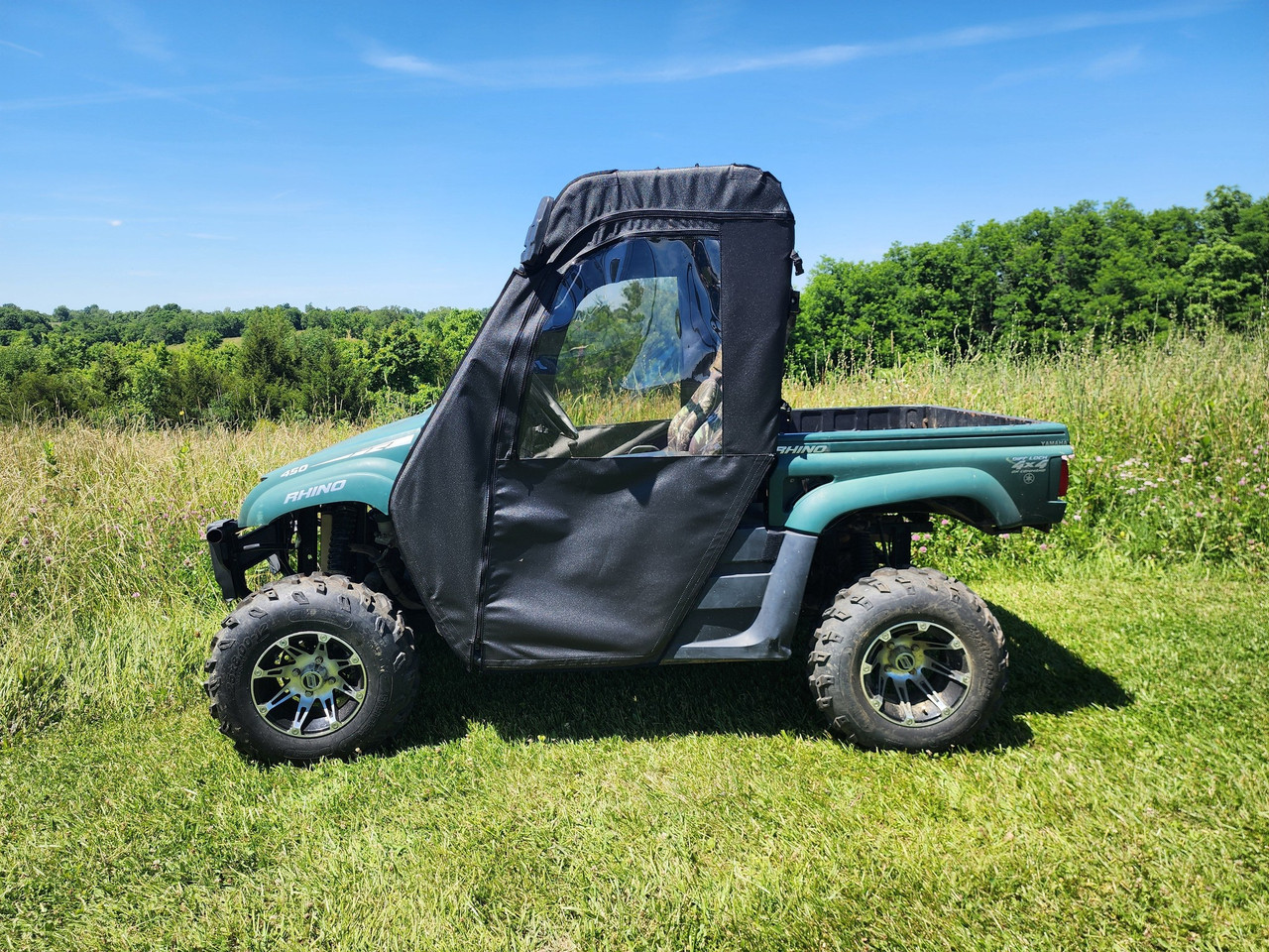 3 Star soft doors installed on a teal Yamaha Rhino side-by-side, side view in a grassy field