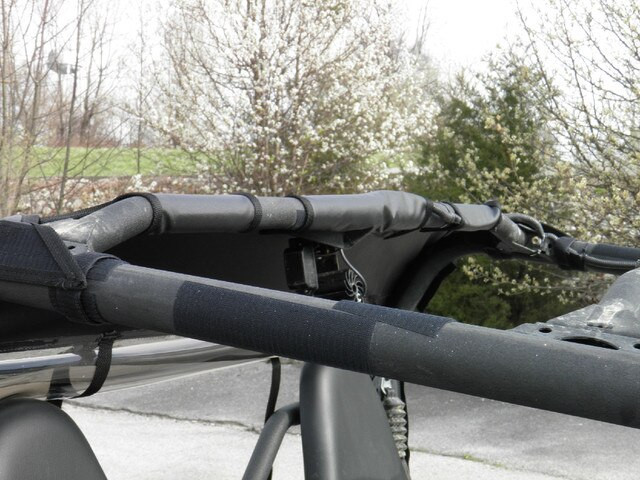 Close-up of the 3 Star soft back panel strap wrapped around the cage crossbar of a Yamaha Wolverine