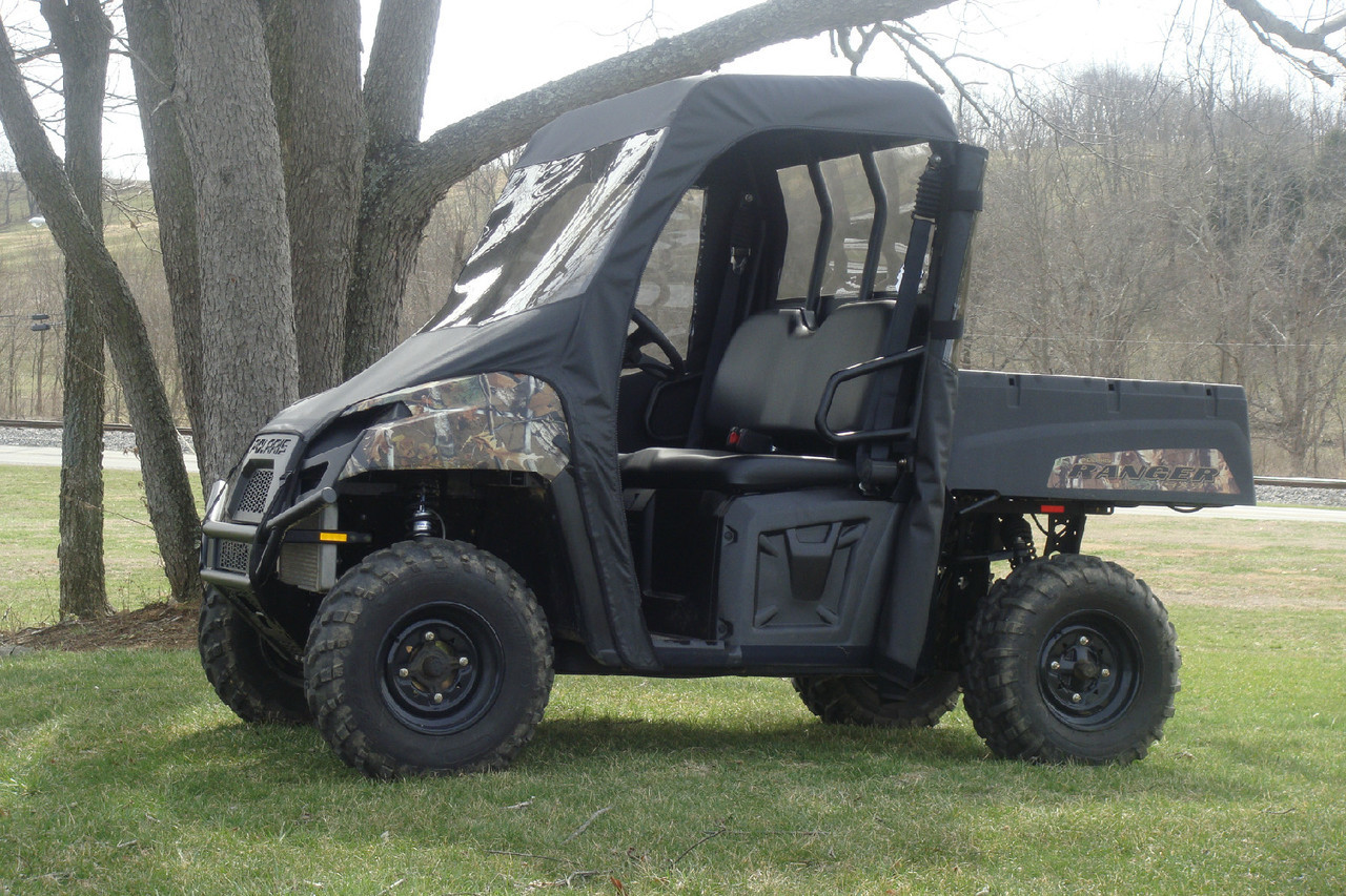 3 Star full cab enclosure doors rolled open on a camouflage Polaris Ranger 570, side view under a tree
