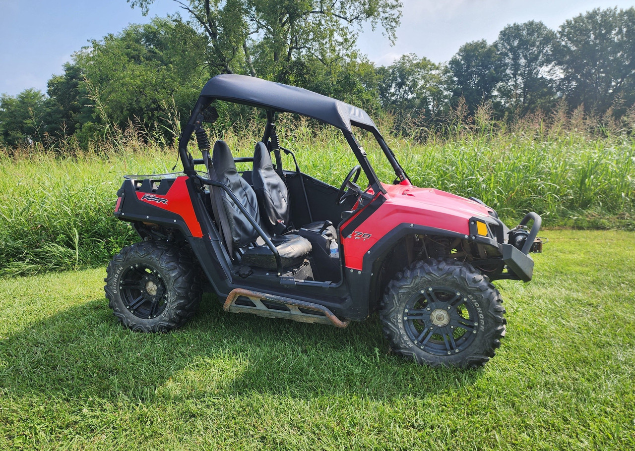 3 Star black soft top on a red Polaris RZR, side view parked on grass with trees behind