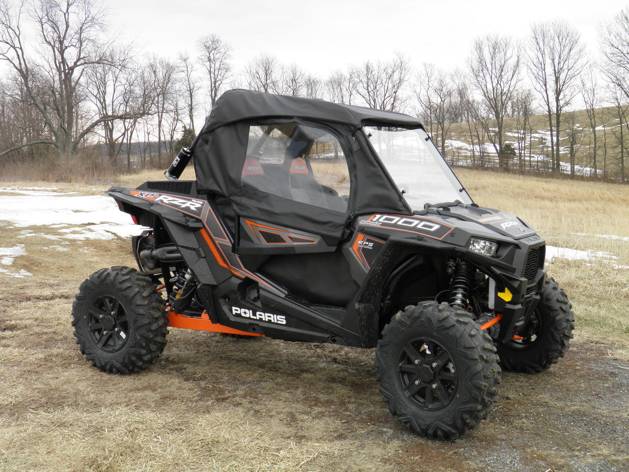 3 Star soft upper doors with clear windows installed on a black and orange Polaris RZR, side front three-quarter view