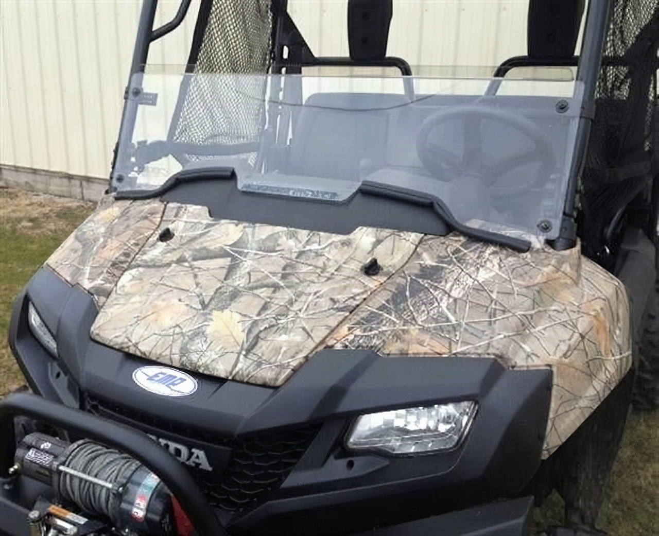 Extreme Metal Products clear Lexan half windshield installed on a camo Honda Pioneer 700, front view with winch