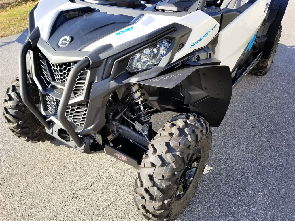 Trail Armor mud flap fender extensions installed on the front of a white Can-Am Maverick Sport, front three-quarter view