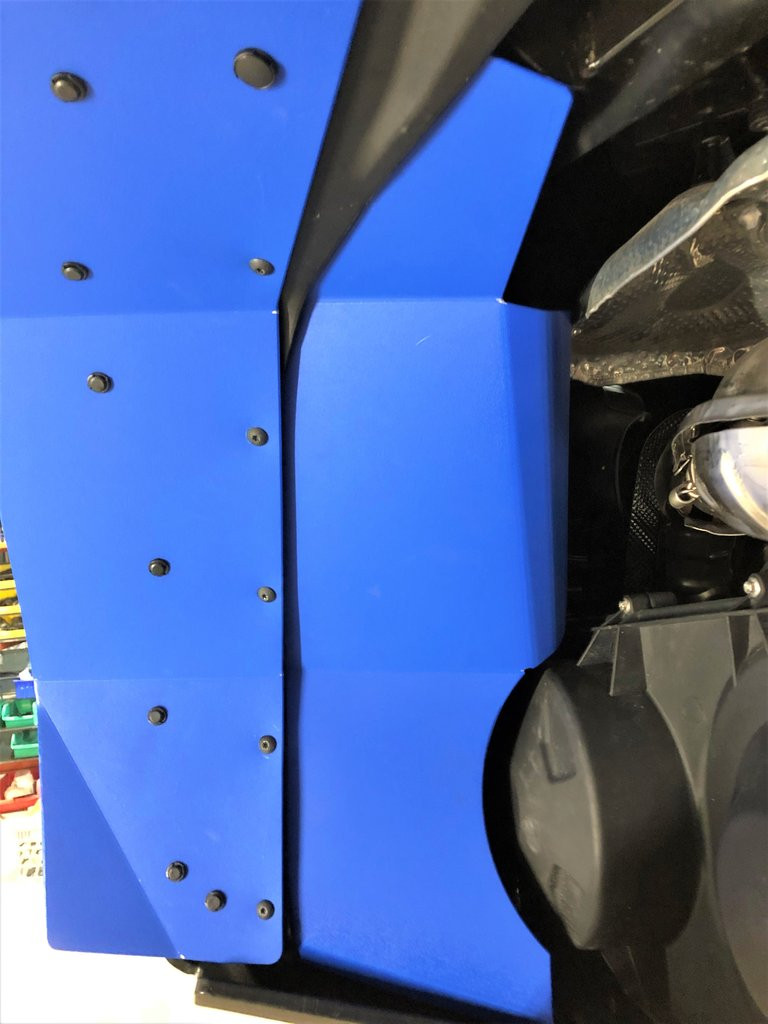Blue color option of the Trail Armor fender extension installed beside a headlight, close-up portrait crop