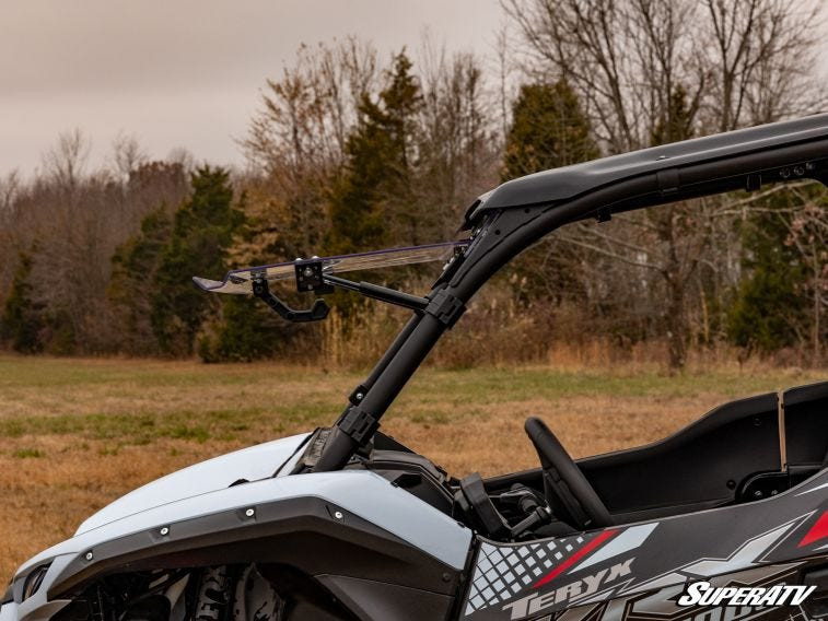 Side view of the Kawasaki Teryx KRX 1000 with the SuperATV windshield flipped open showing the hinge arm
