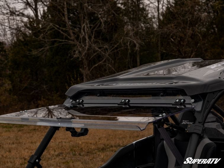 Rear quarter view of the SuperATV flip windshield fully open under the Kawasaki Teryx KRX 1000 roof