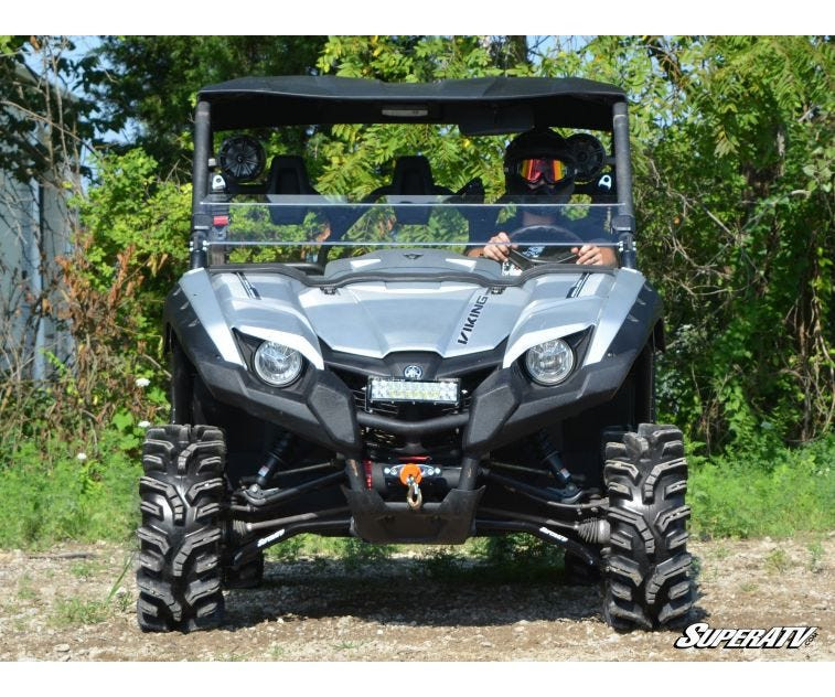 Front view of a silver Yamaha Viking lifted with the SuperATV 2-inch lift kit, mud tires and driver aboard