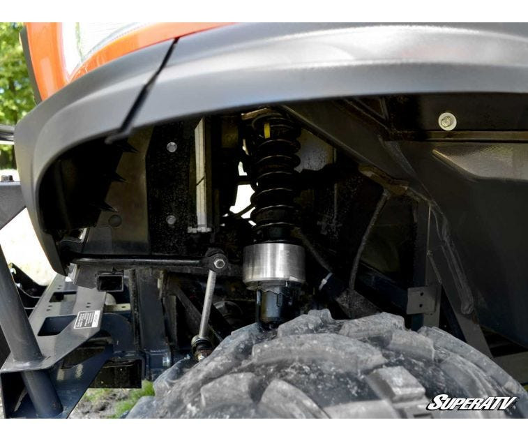 Close-up of a SuperATV lift spacer on the Kubota RTV X Series coilover shock inside the wheel well