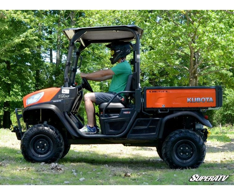 Side profile of a Kubota RTV X Series with the SuperATV 2 inch lift kit installed and a driver at the wheel